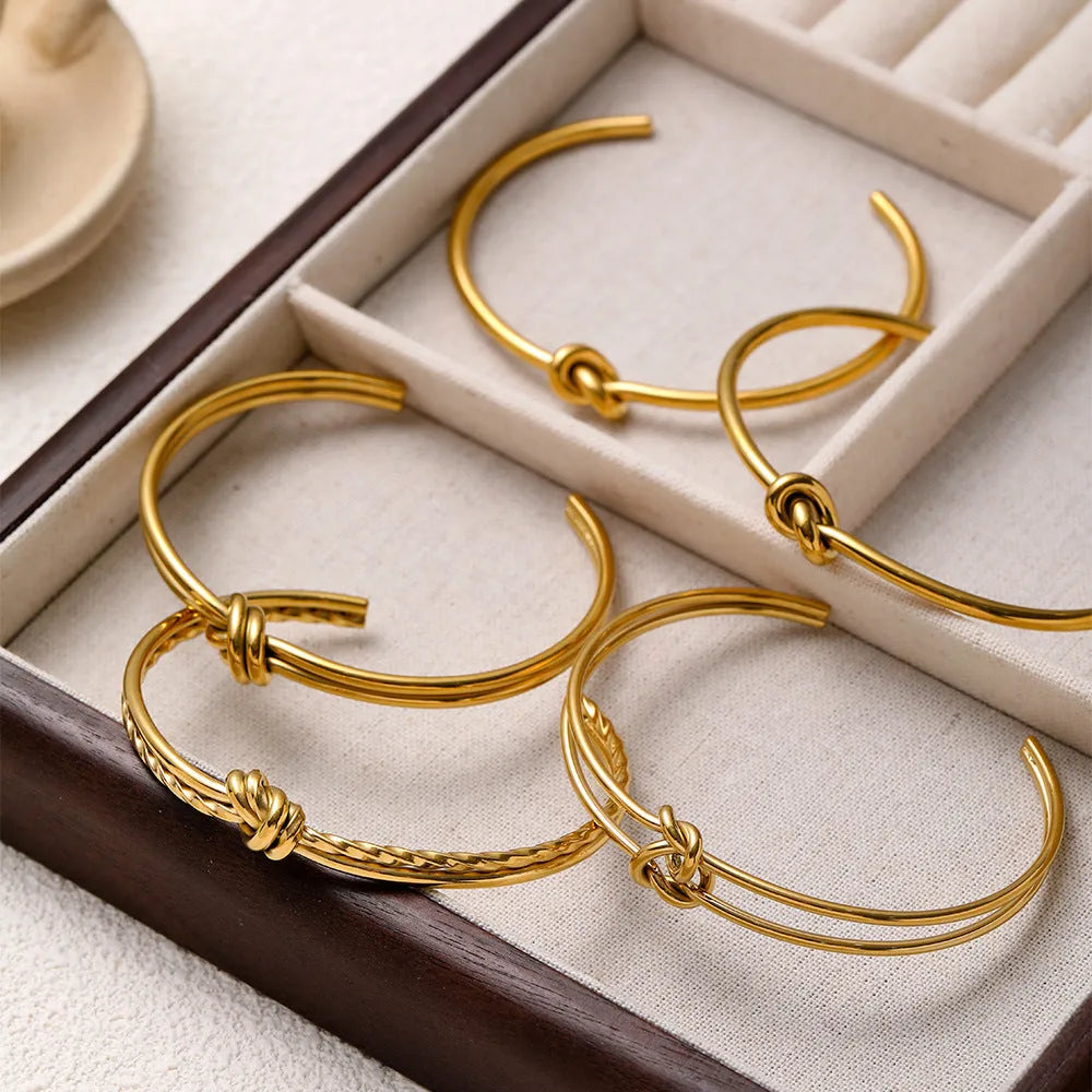 Women's adjustable stainless steel bracelet with C-shaped open design, double-layer construction and knotted detailing in gold or silver finish