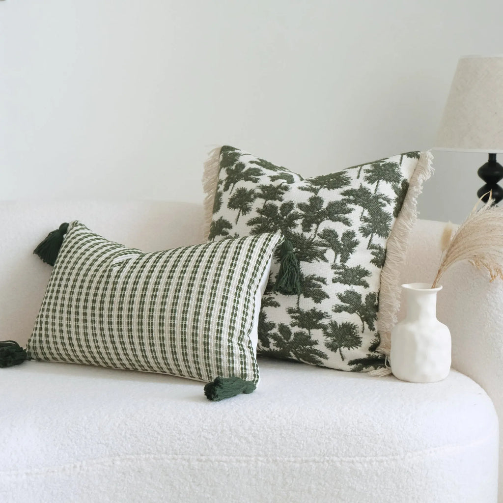 Green patterned cotton linen decorative pillow on a bed, shown in striped, botanical, and leaf designs.