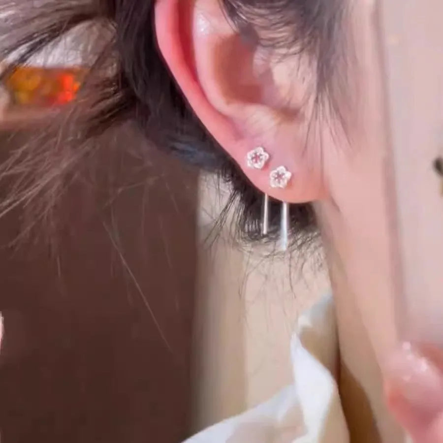 Pair of silver hollow flower dangle earrings with petal detail on alloy posts