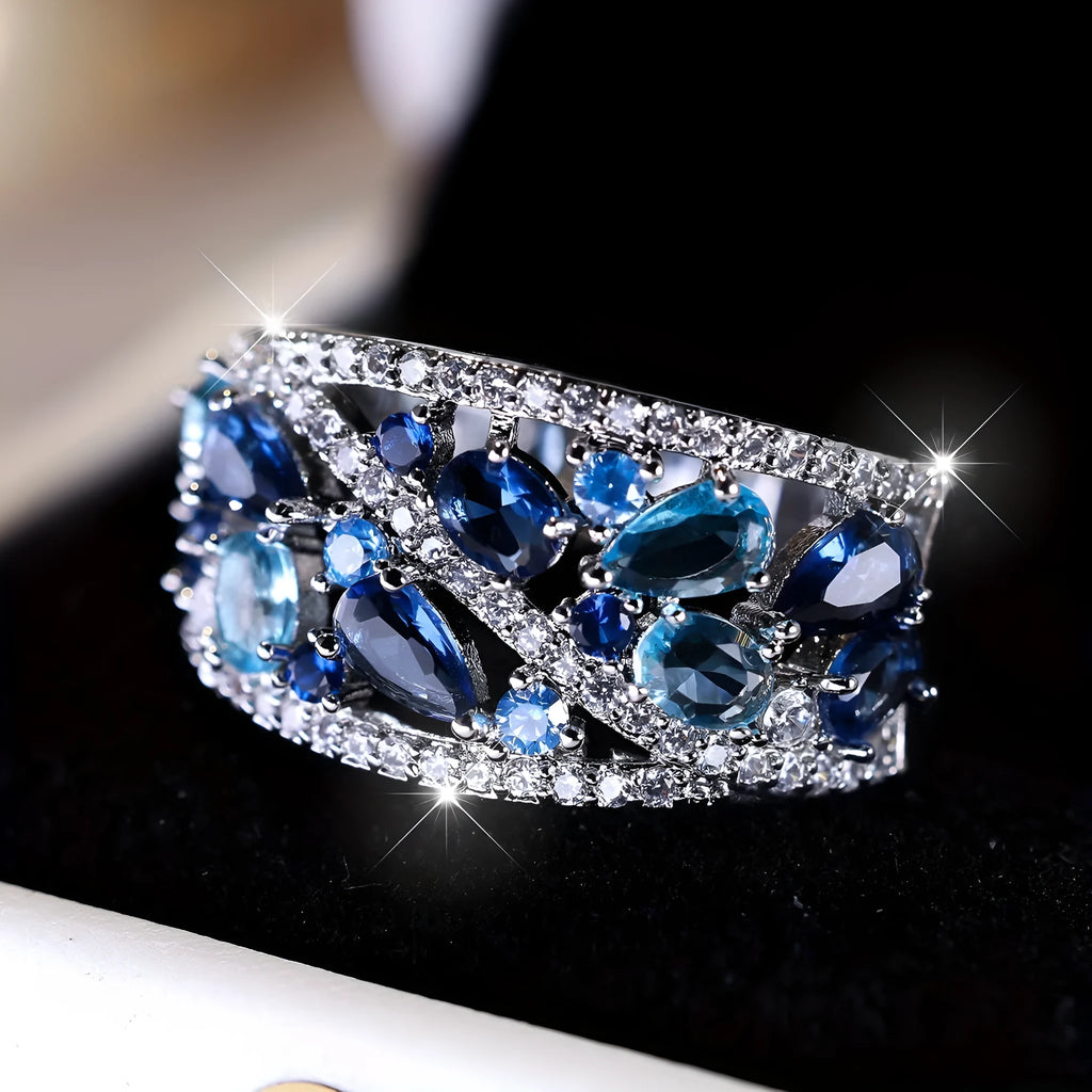 Women's round hollow fashion ring in copper with choice of gold or platinum finish and blue or white stone detail.