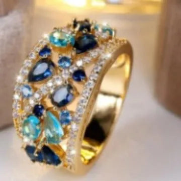 Women's round hollow fashion ring in copper with choice of gold or platinum finish and blue or white stone detail.