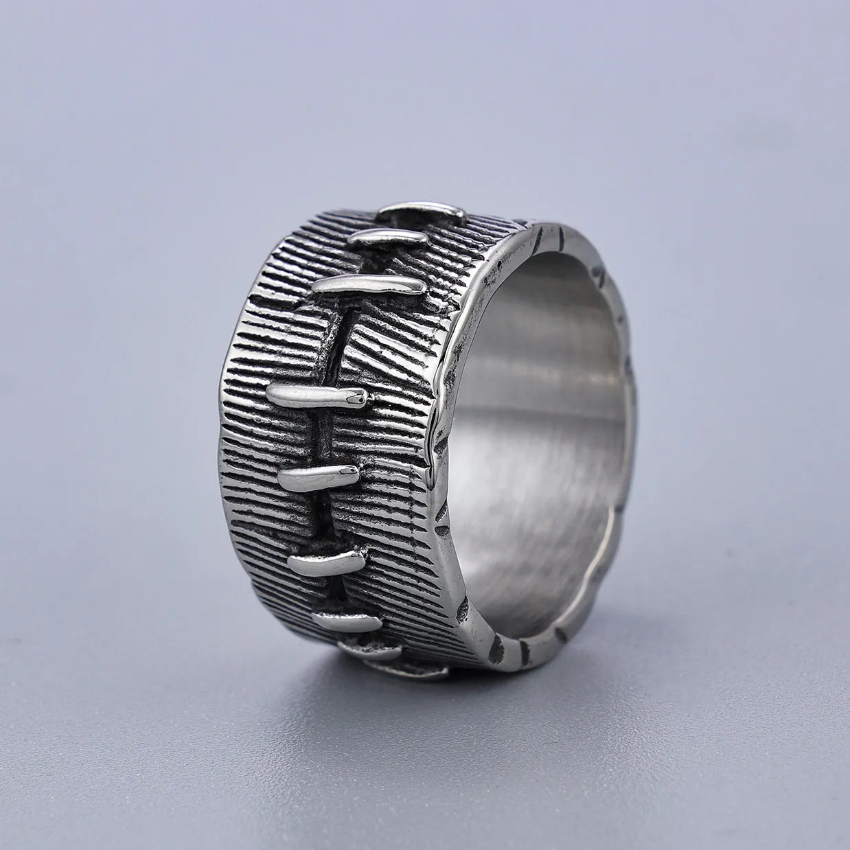 A geometric U-shaped dark punk double ring made from titanium steel in a retro colour, shown on a finger.