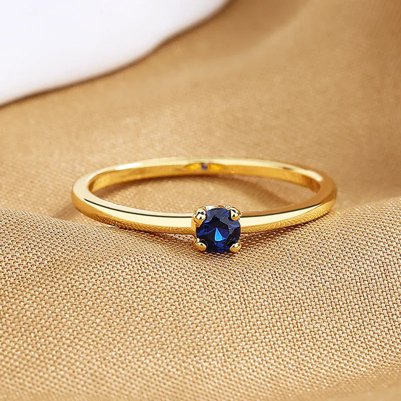 Copper geometric circle ring for women with a single diamond style in blue, green, red, or white on a size guide.