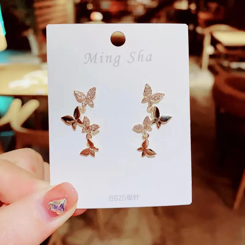 Gold-coloured copper butterfly earrings with four-wing design and drop silhouette for women