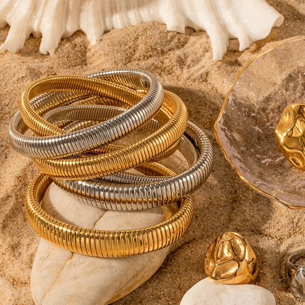 Gold titanium steel bracelet with exaggerated vertical stripe ring pattern and elastic band.