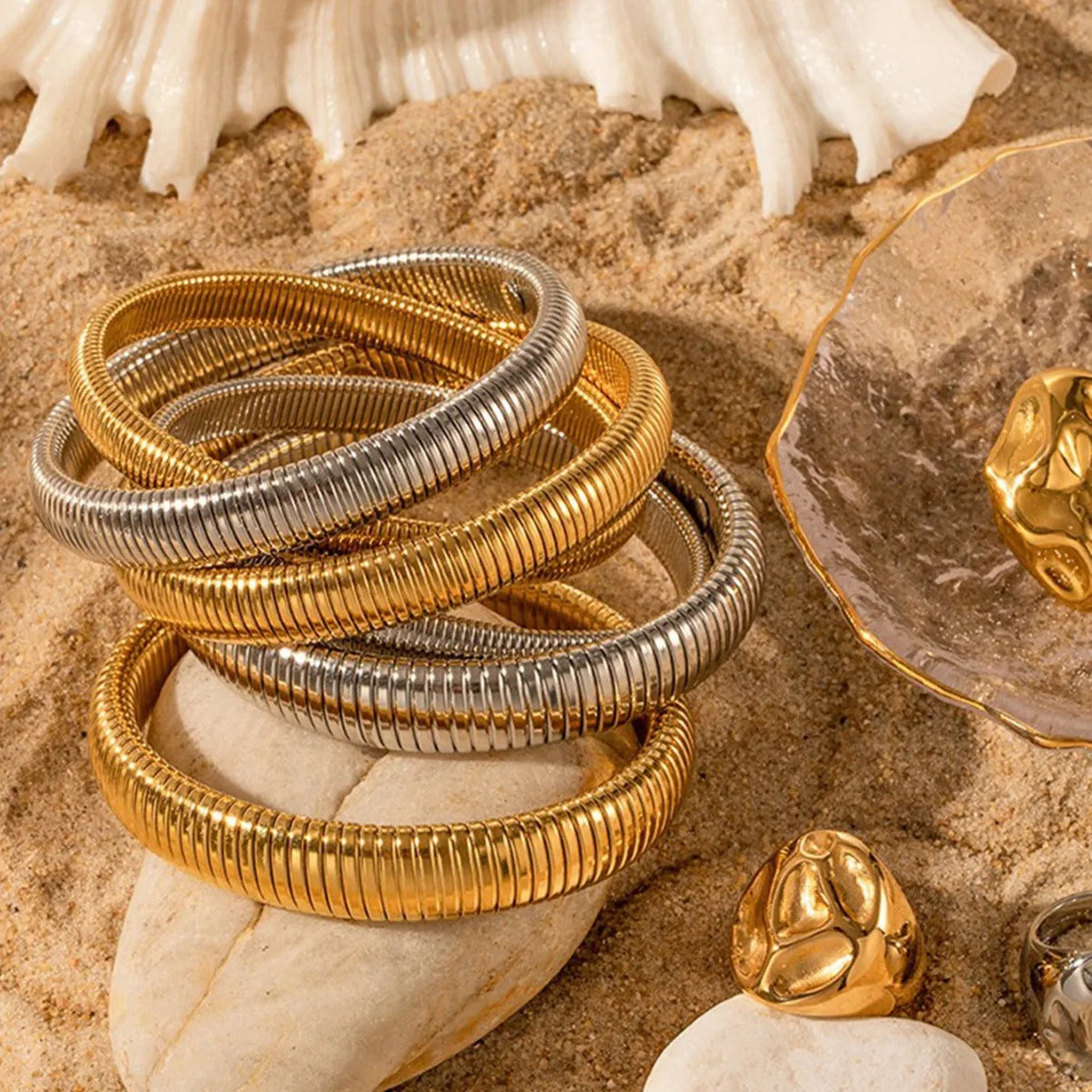 Gold titanium steel bracelet with exaggerated vertical stripe ring pattern and elastic band.