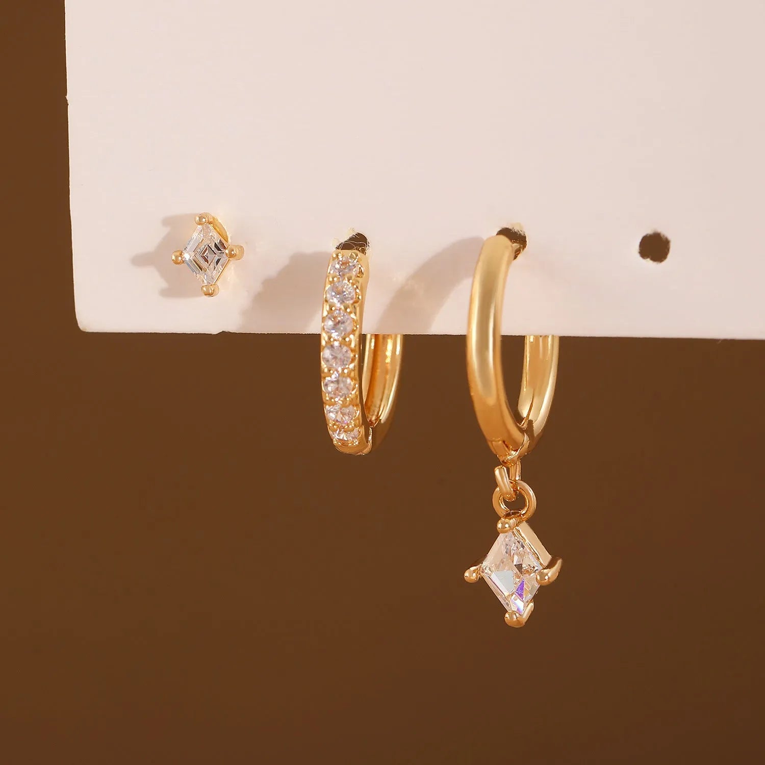 Geometric ladies earring set with zircon detailing in gold and silver options showing drop, stud, and clip-on pieces