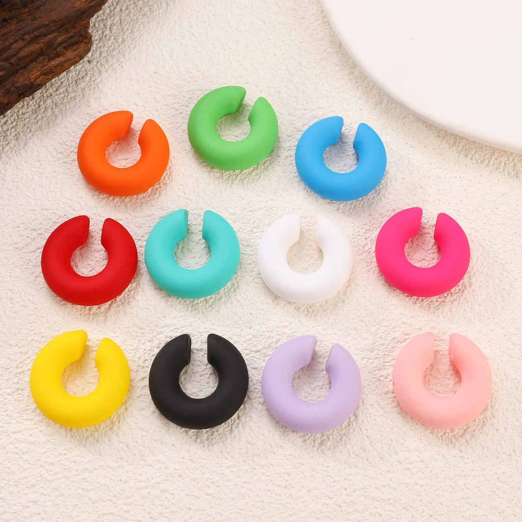C-shaped clip-on earrings with round geometric shape and matte coarse finish in assorted candy colours.