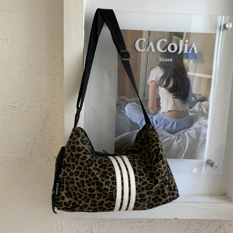 Sports-style cross-body messenger bag in leopard print pattern with decorative stitching details