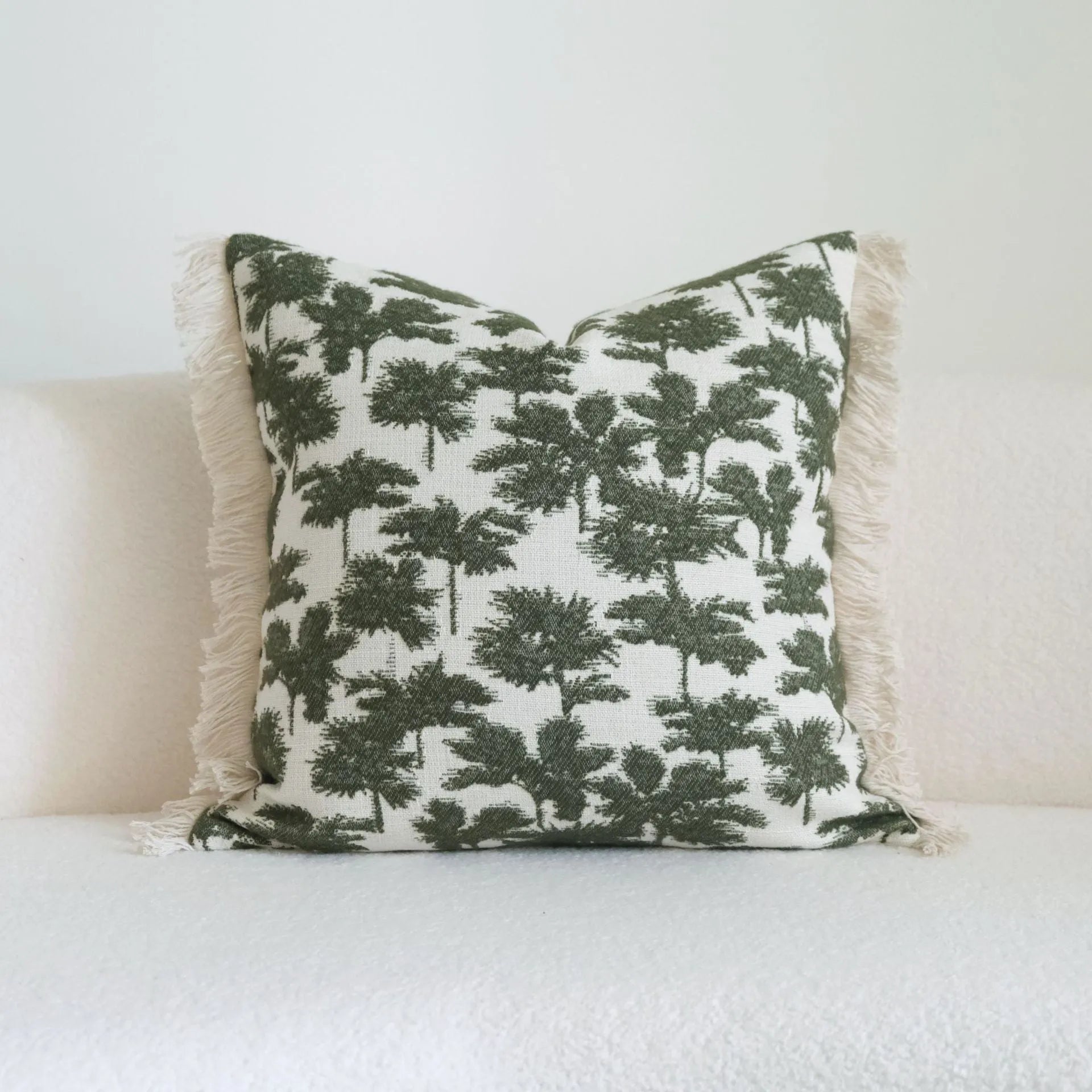 Green patterned cotton linen decorative pillow on a bed, shown in striped, botanical, and leaf designs.