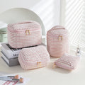 Four cube-shaped flannelette make-up bags in different colours: pink, khaki, pink dots, blue dots