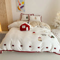 Winter Christmas cartoon patterned bedding four-piece set showing duvet cover, sheet, and pillowcases in pastel colours.