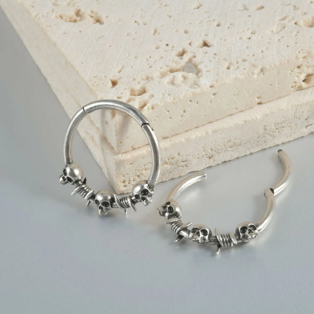 Copper puncture earrings in ancient silver and gold featuring single and three ghost head punk designs.