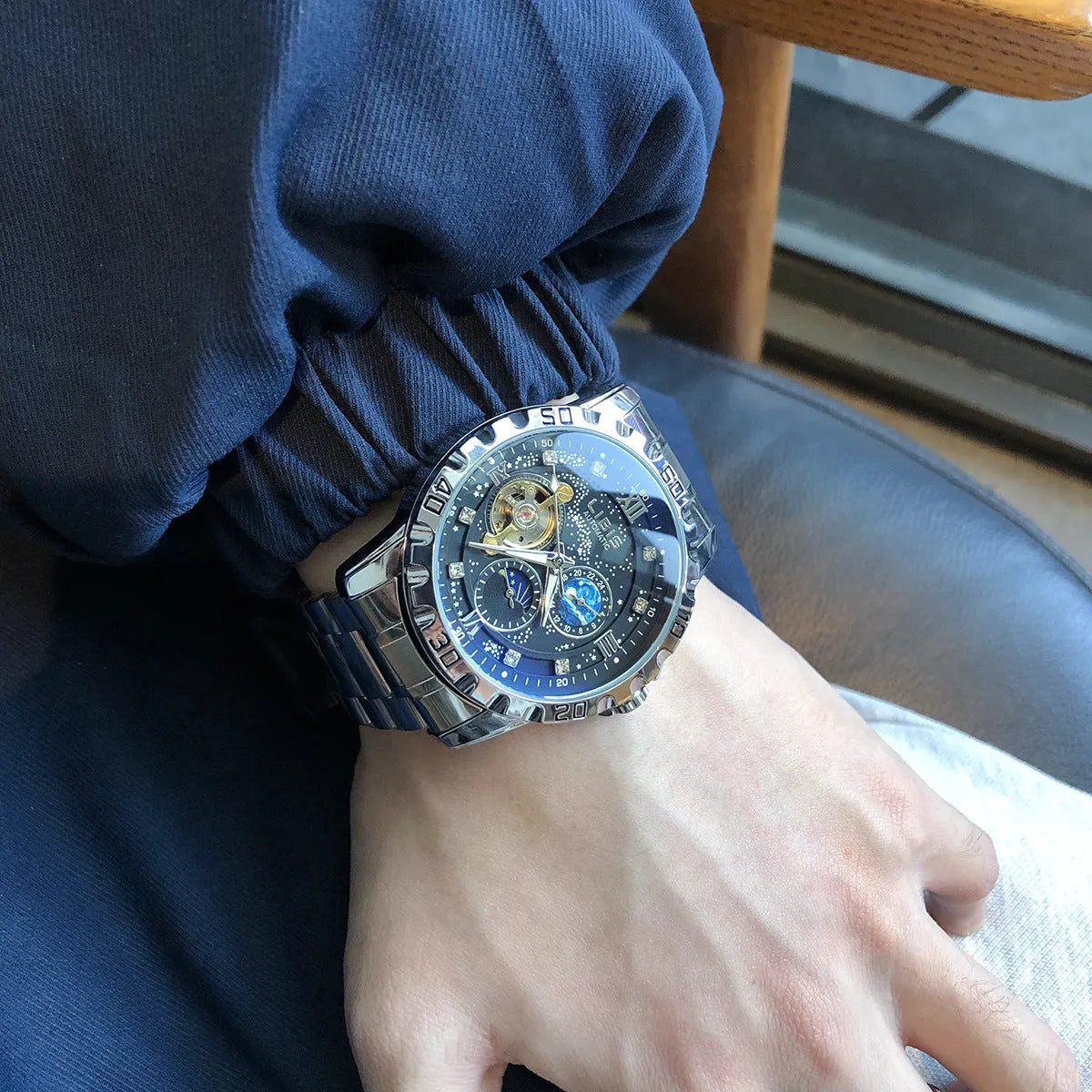Men's silver automatic mechanical watch with black starry dial and luminous hands on steel strap