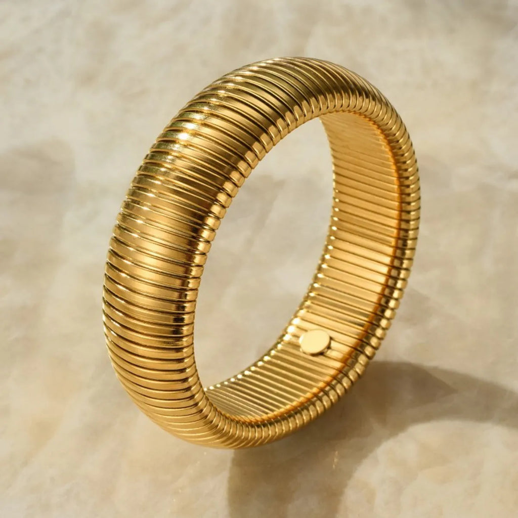 Gold titanium steel bracelet with exaggerated vertical stripe ring pattern and elastic band.