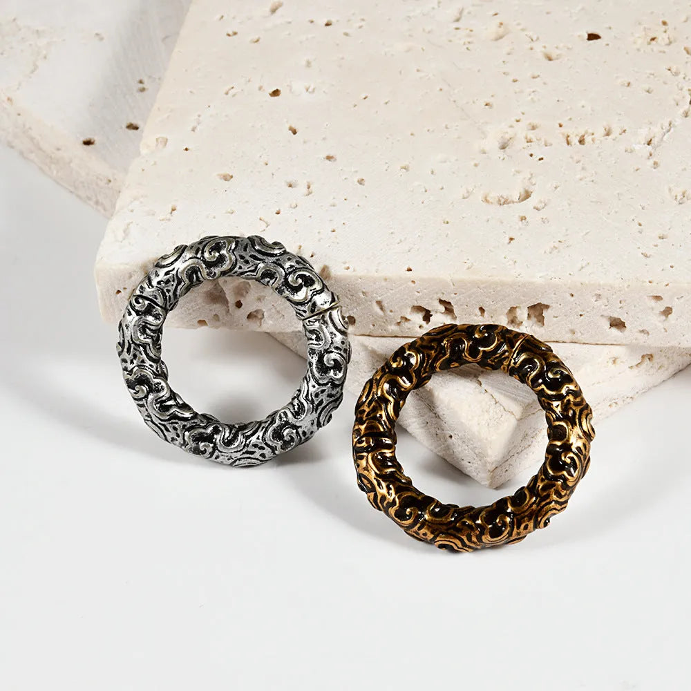 A pair of stainless steel fashion earrings with a geometric totem pattern in an electroplated finish.