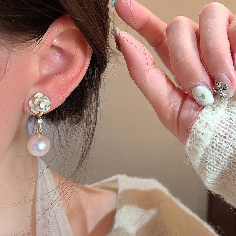 A pair of camellia flower-shaped stud earrings for women in a metallic alloy finish.