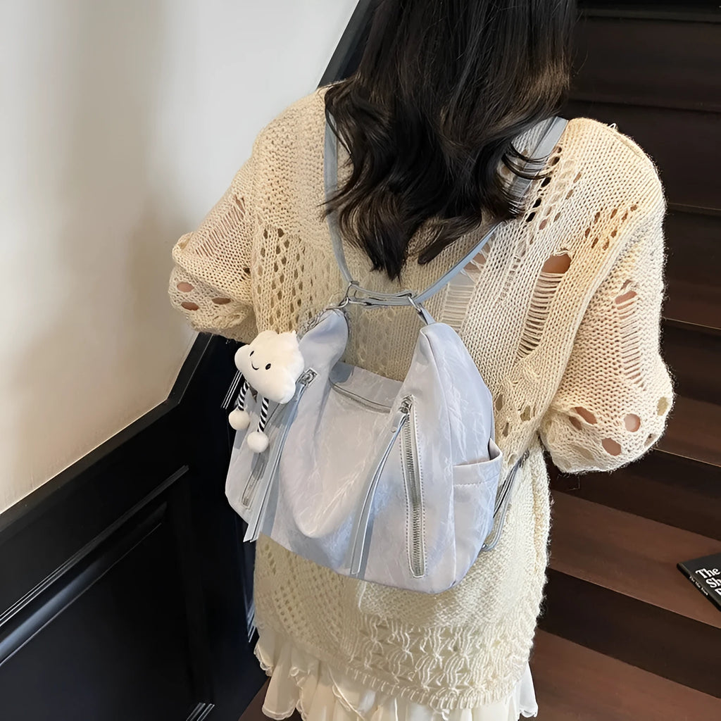 Women's soft PU leather fashion backpack in black, shown with detachable pendant.