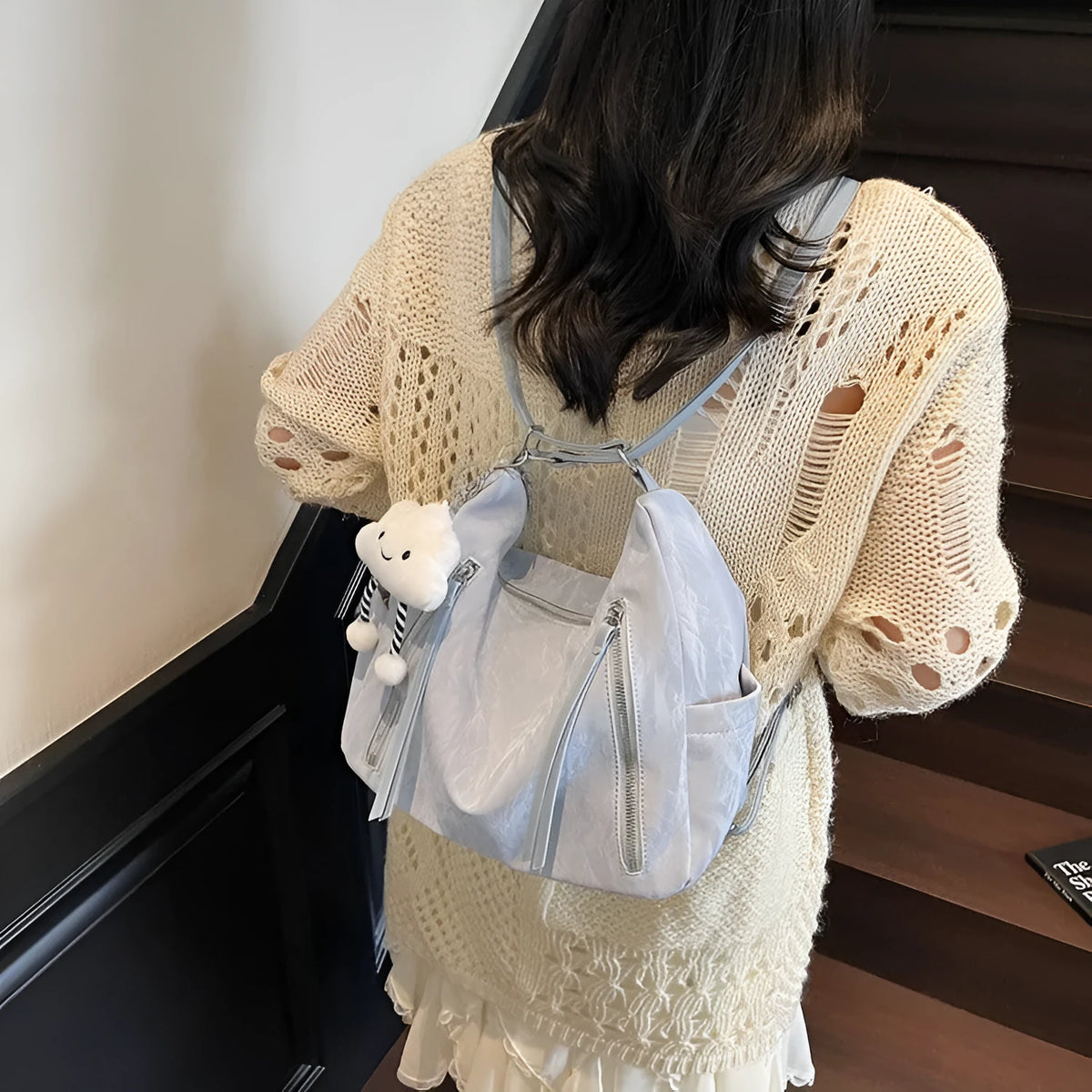 Women's soft PU leather fashion backpack in black, shown with detachable pendant.
