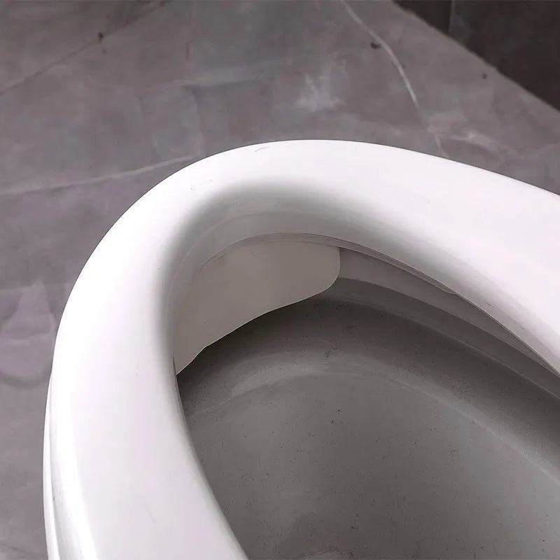 White PVC urine blocking board for children's toilet training placed around toilet bowl