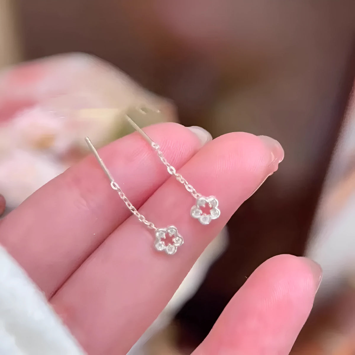 Pair of silver hollow flower dangle earrings with petal detail on alloy posts