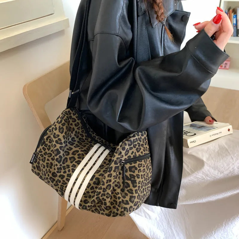Sports-style cross-body messenger bag in leopard print pattern with decorative stitching details