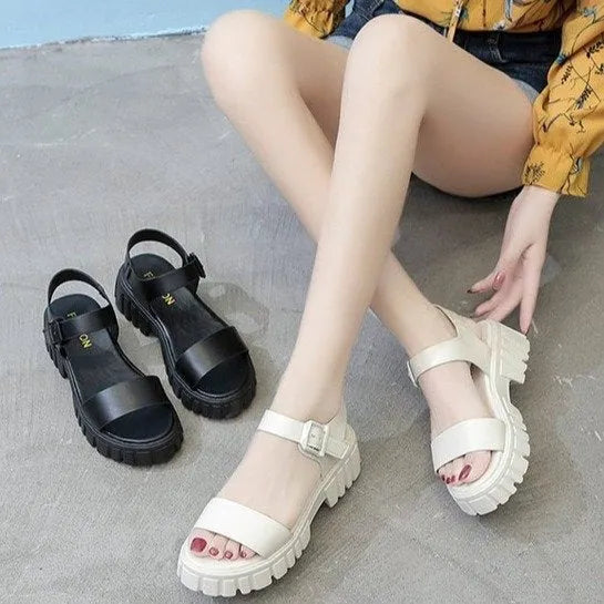 Women's beige peep toe platform sandals with an ankle-strap buckle on a wooden floor.