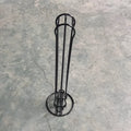 Black wrought iron coffee capsule storage rack holding pods on display shelves.