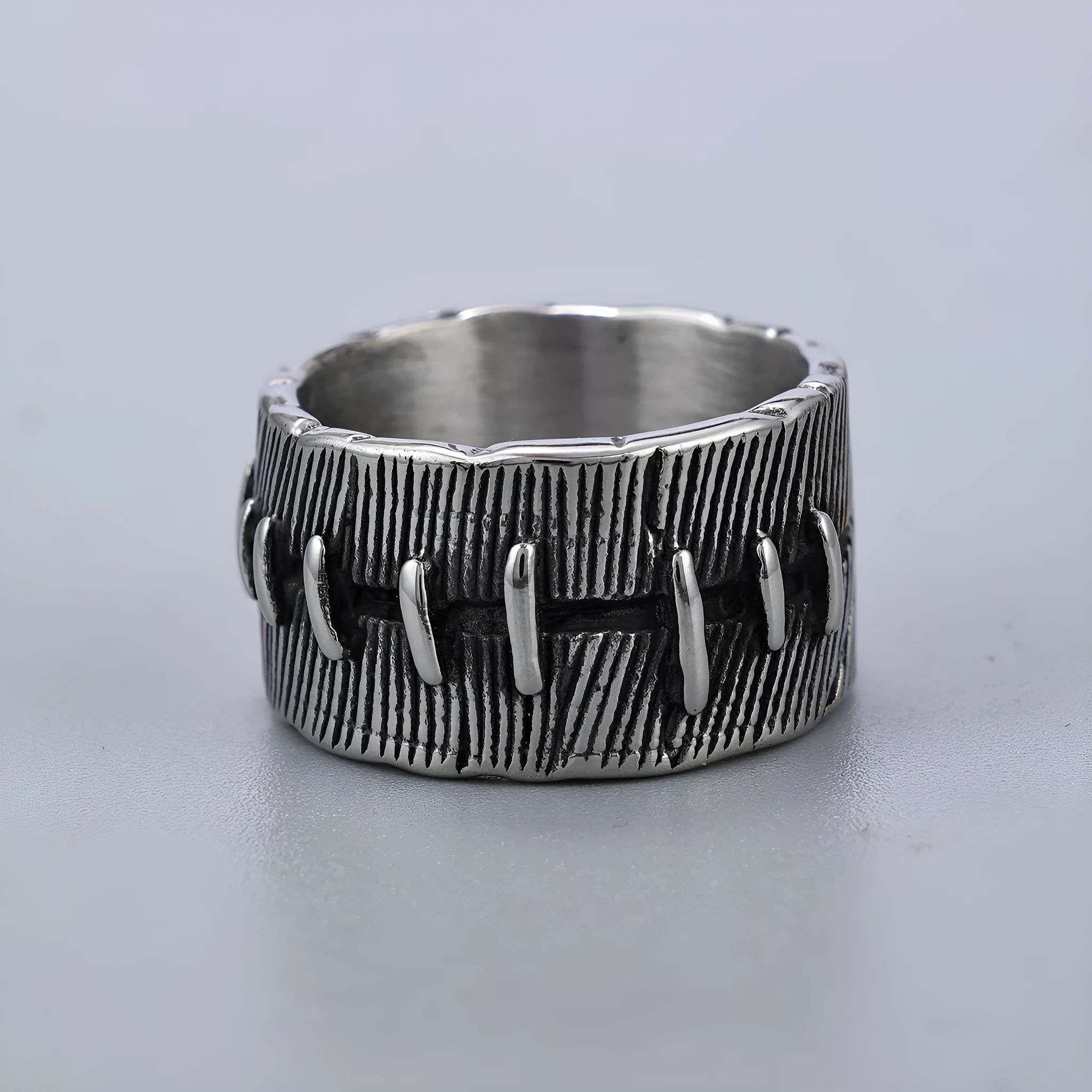 A geometric U-shaped dark punk double ring made from titanium steel in a retro colour, shown on a finger.
