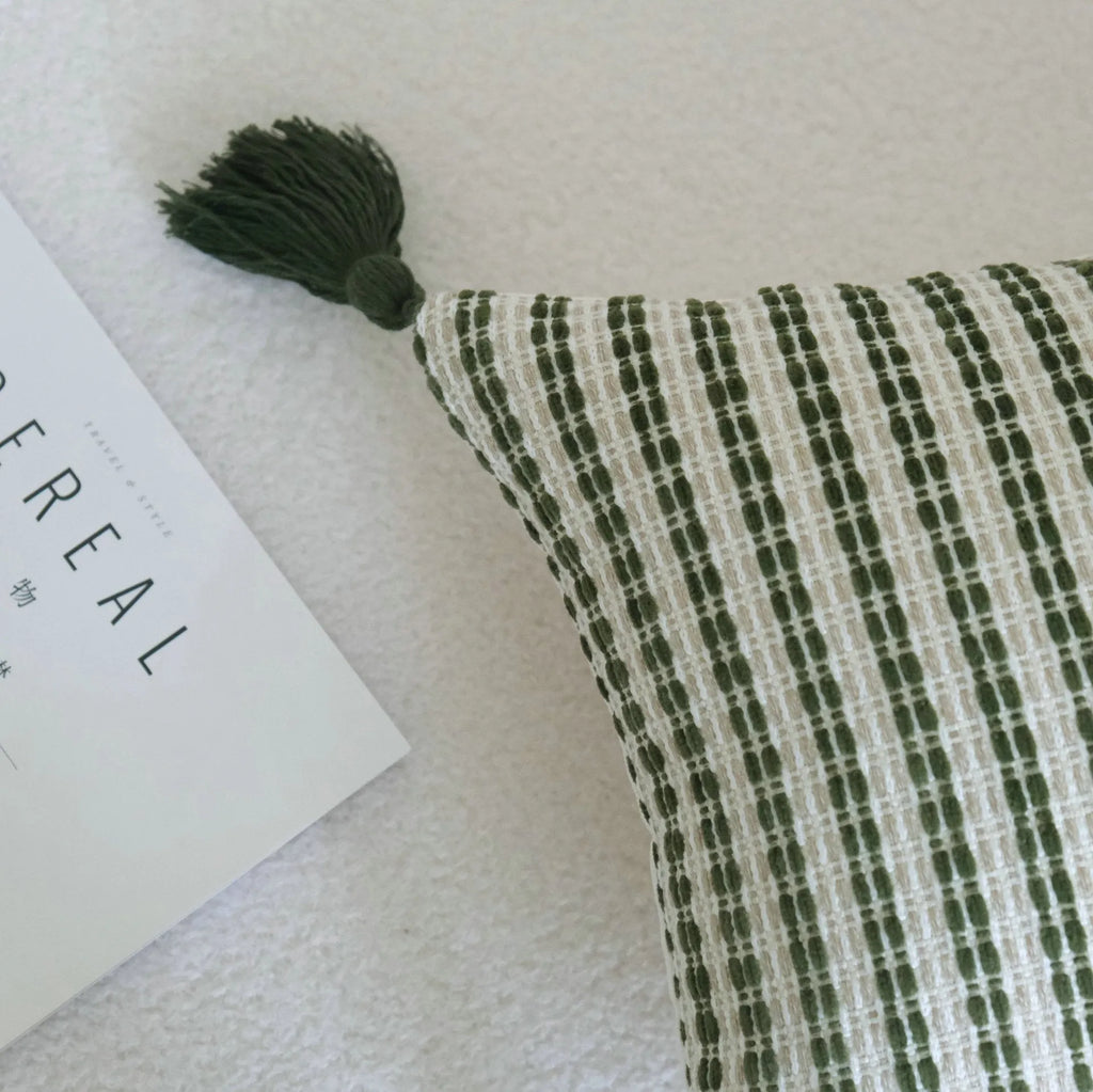 Green patterned cotton linen decorative pillow on a bed, shown in striped, botanical, and leaf designs.