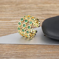 Copper ring with gold plating showing a wide, layered band fully set with green zircon stones.