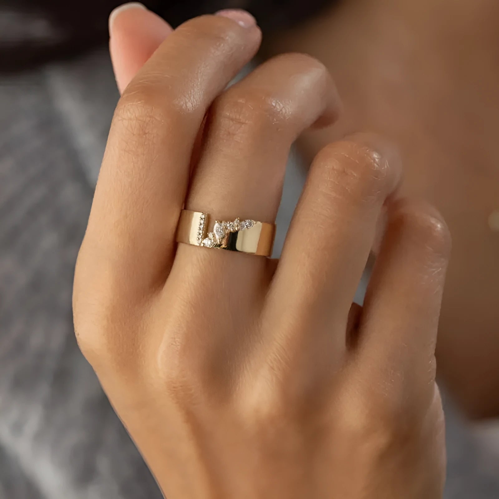 Gold electroplated copper ring for women with shining zircon accents, shown on a finger.
