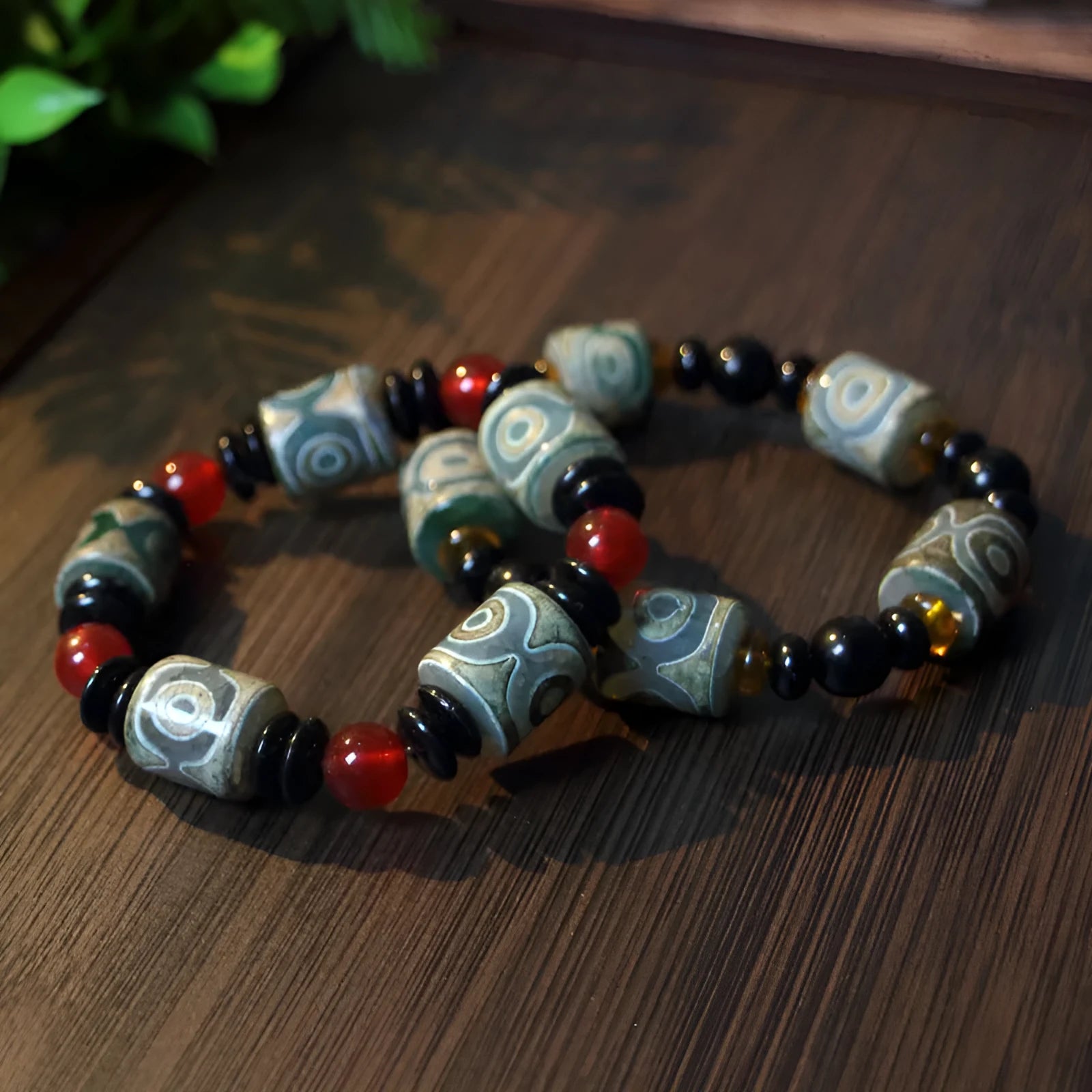 Distressed agate bracelet with traditional Tibetan dzi beads including three-eye and Nine Eyes designs.