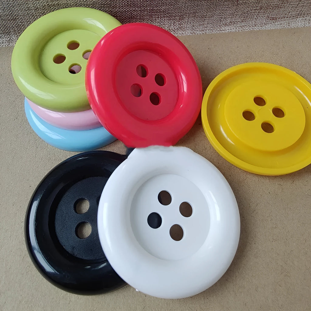Assortment of oversized round plastic buttons in multiple colours showing four-hole design.