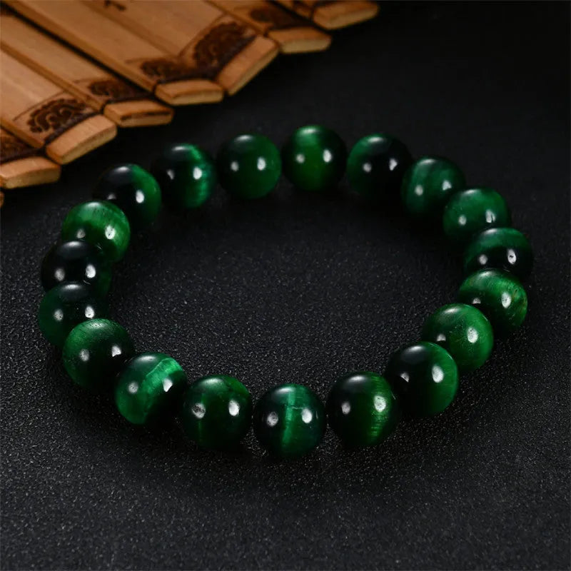 Green tiger eye gemstone bracelet with geometrically polished beads on a white background.