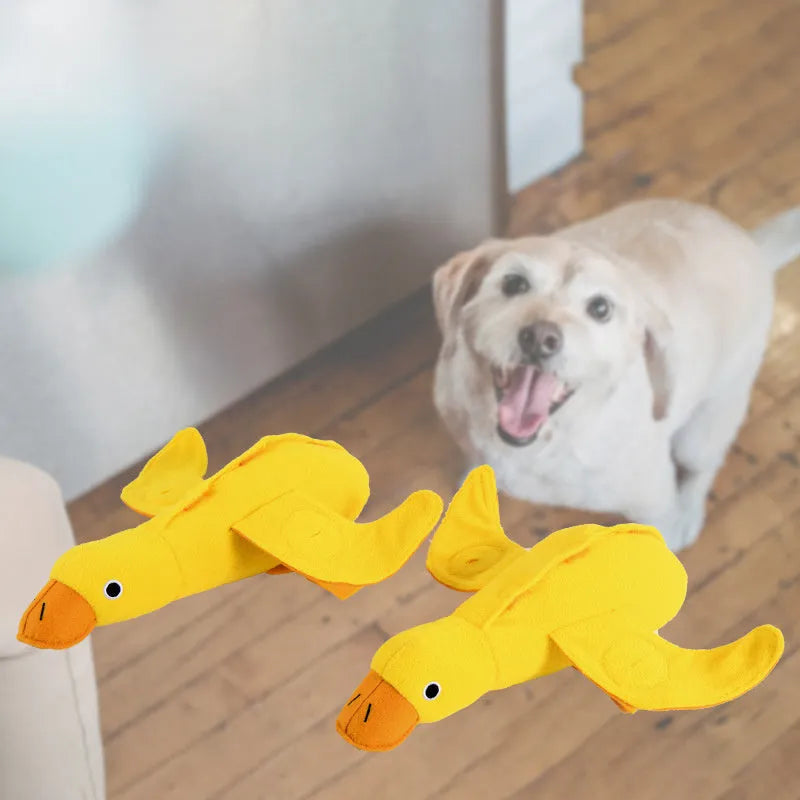 Yellow plush teddy dog toy with attached duck doll and food leak compartments for pet training