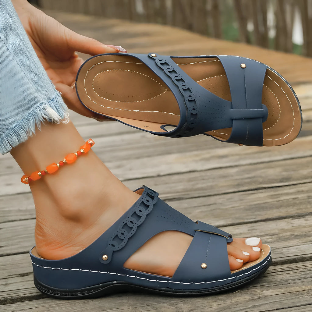 Blue Roman style slippers with a fish mouth toe holder and slope heel on a rubber sole.