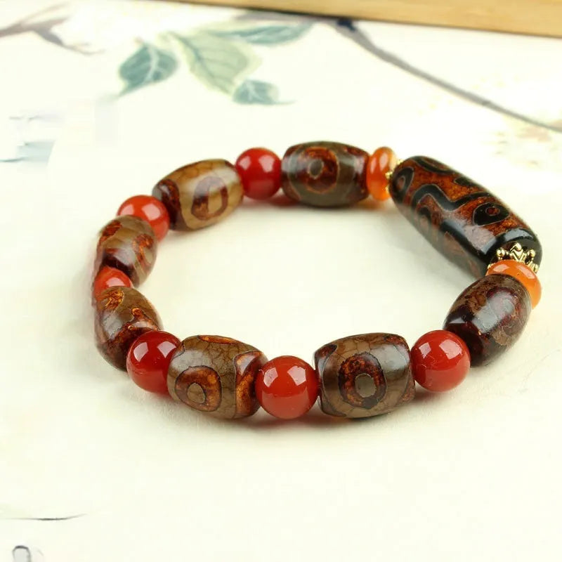 Distressed agate bracelet with traditional Tibetan dzi beads including three-eye and Nine Eyes designs.