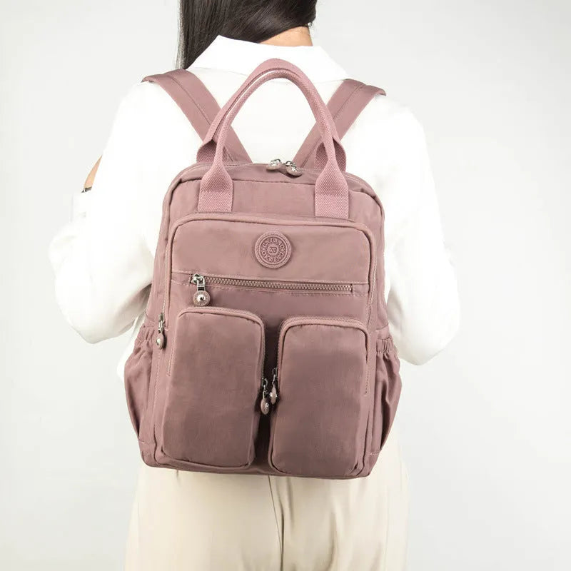 Women's waterproof nylon travel backpack showing internal organisation compartments and colour options