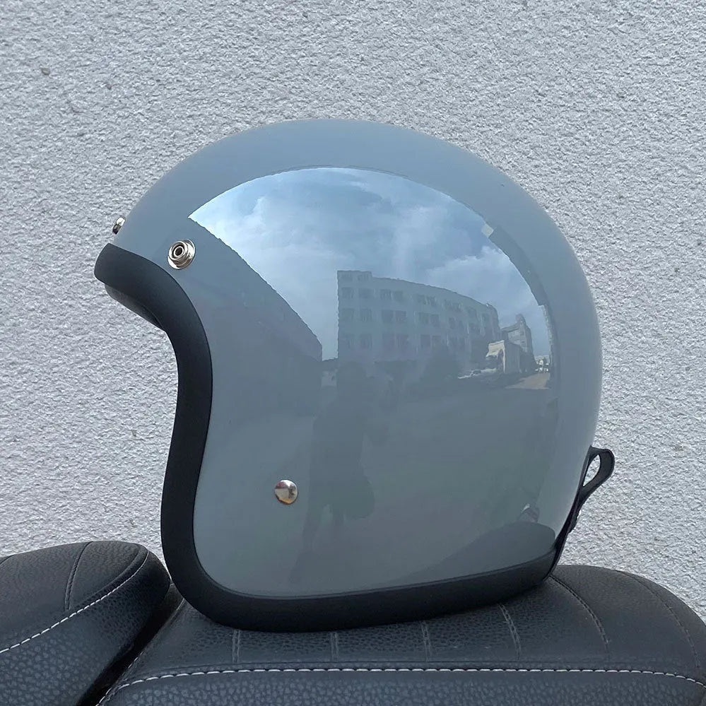 Retro-style half-shell motorcycle helmet in fibreglass, shown in a cement grey colour option.