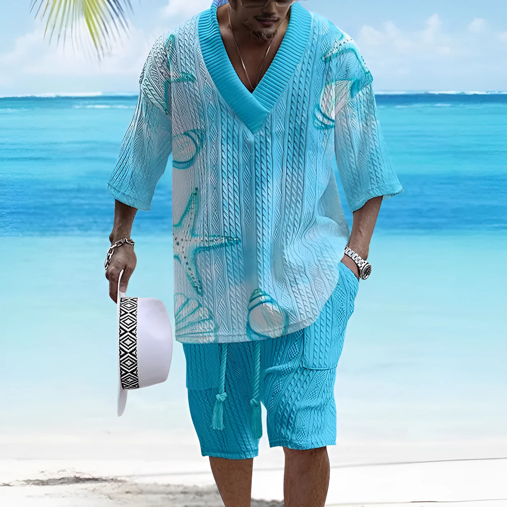 Man wearing a loose light blue short sleeve casual suit top with matching shorts.