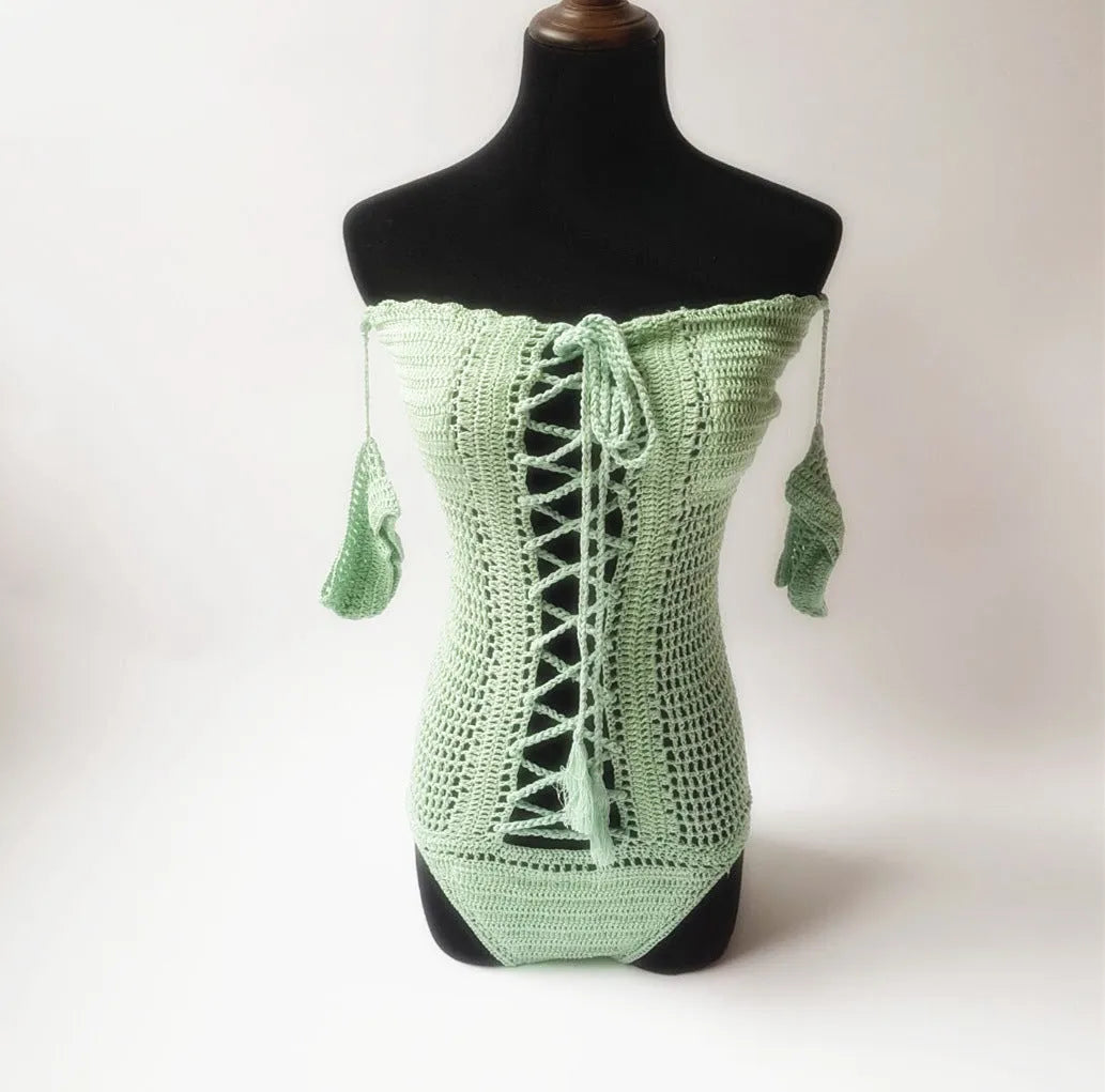Women's off-shoulder one-piece swimsuit in light pink on a mannequin.