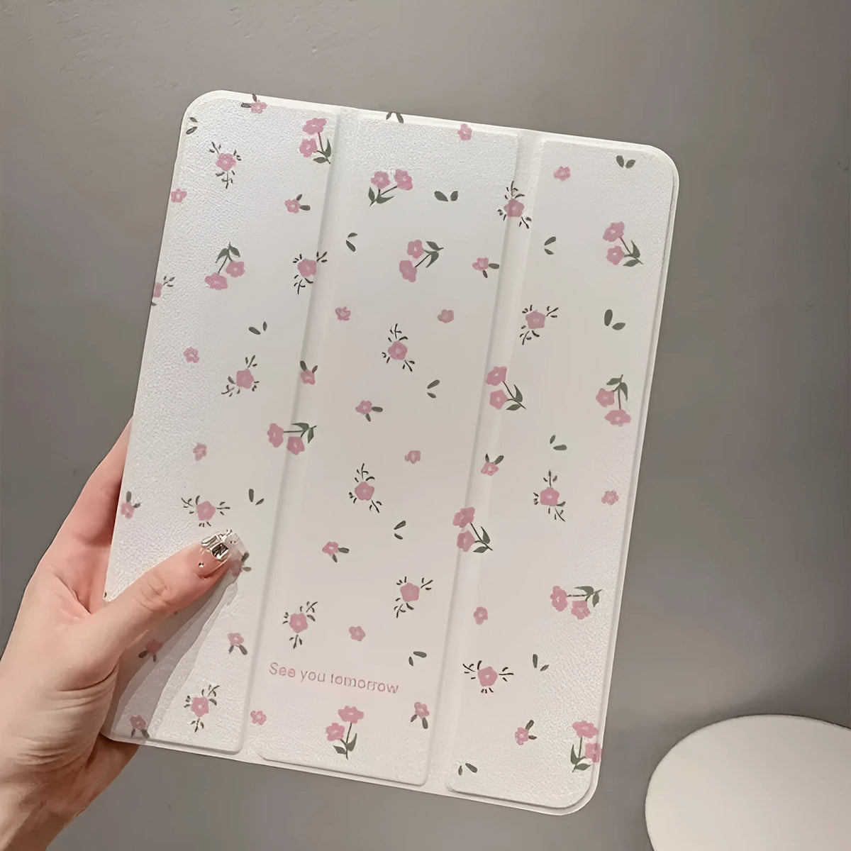 Transparent tri-fold iPad case with floral pattern showing built-in stand angle.