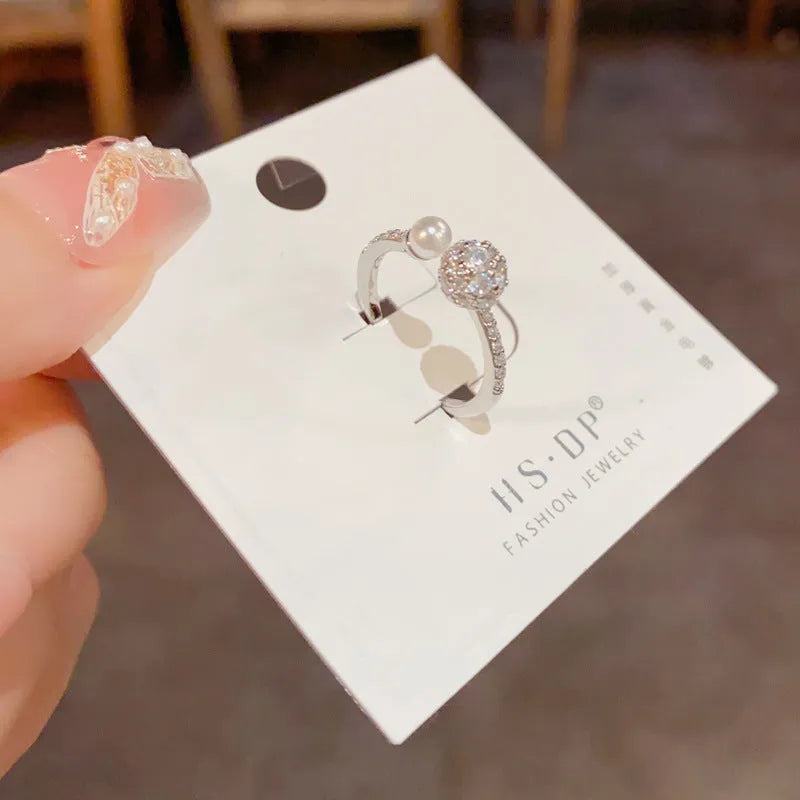 Open-end pearl ring with round zircon detail in geometric shape, gold and silver colour options