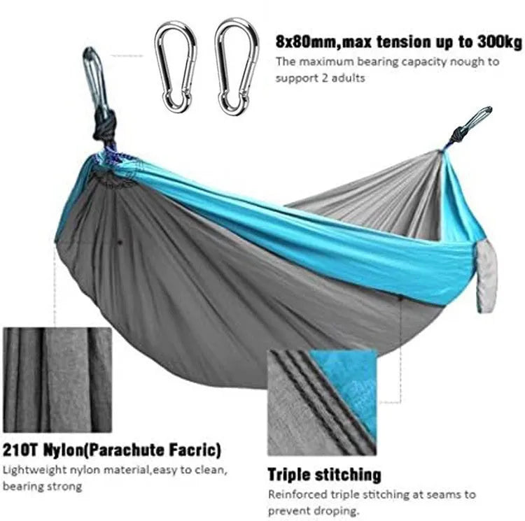Blue nylon parachute cloth camping hammock hung between two trees.