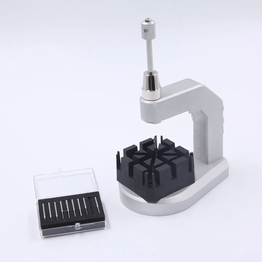 Silver-toned tool steel press strap removal tool for watches and jewellery on a plain background.