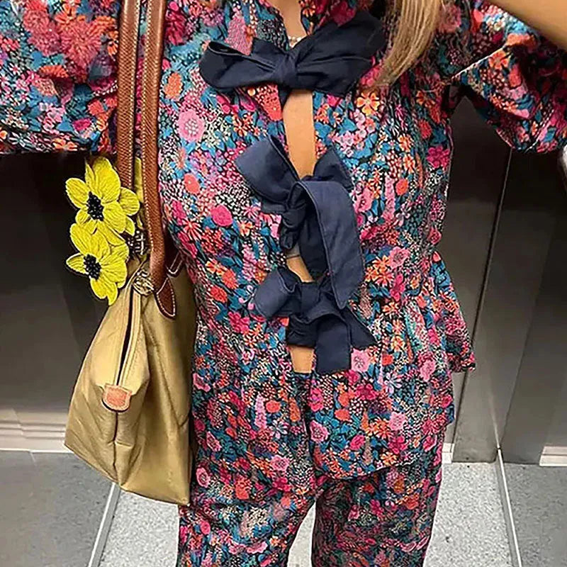 Floral print trousers suit with tie-neck blouse and puff sleeves on hanger