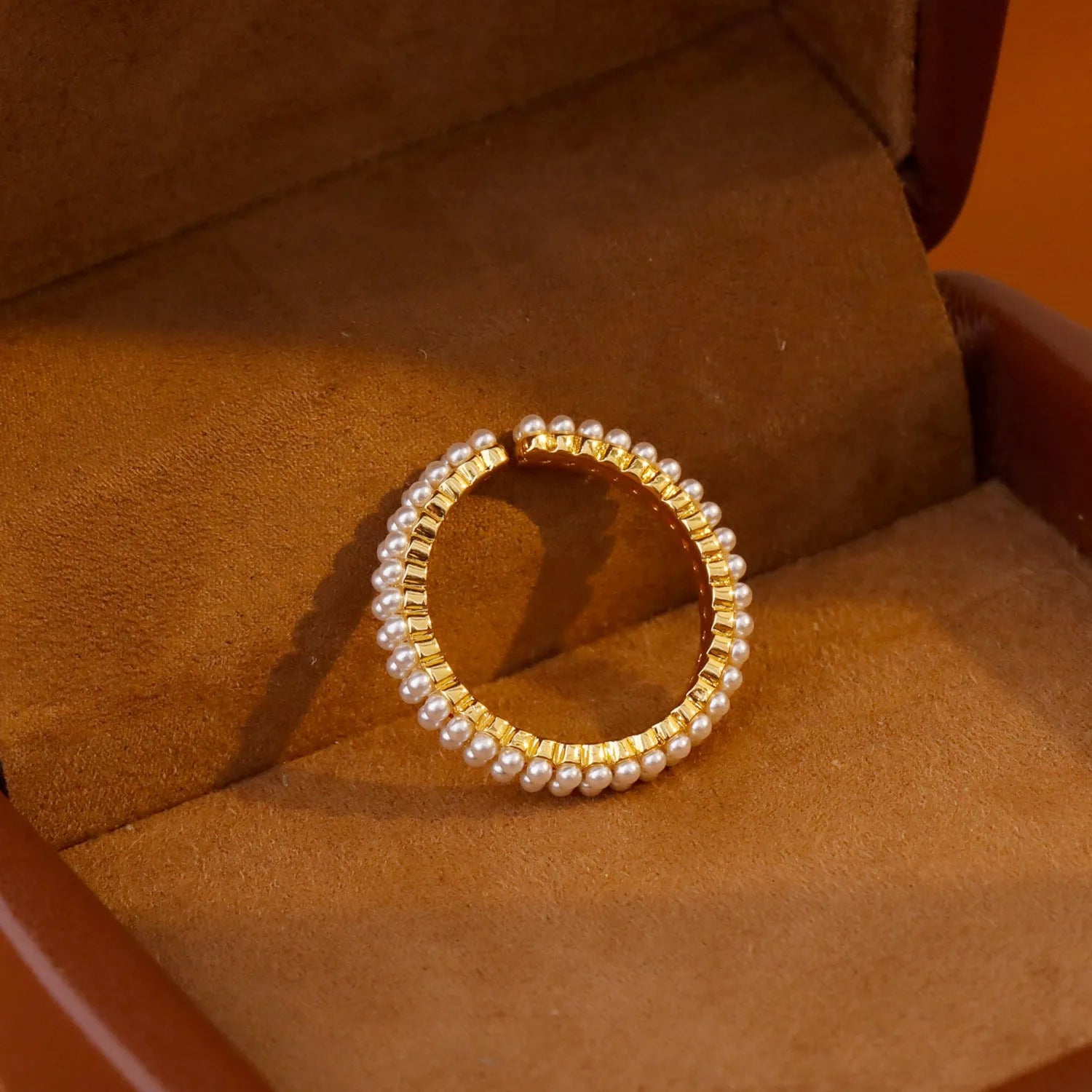 Gold coloured open mouth ring with geometry modelling and round design elements on copper base