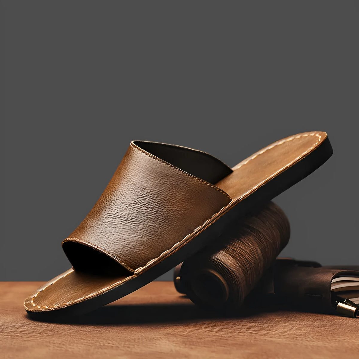 Brown leather men's open-toe sandals with a rubber sole on a neutral background.