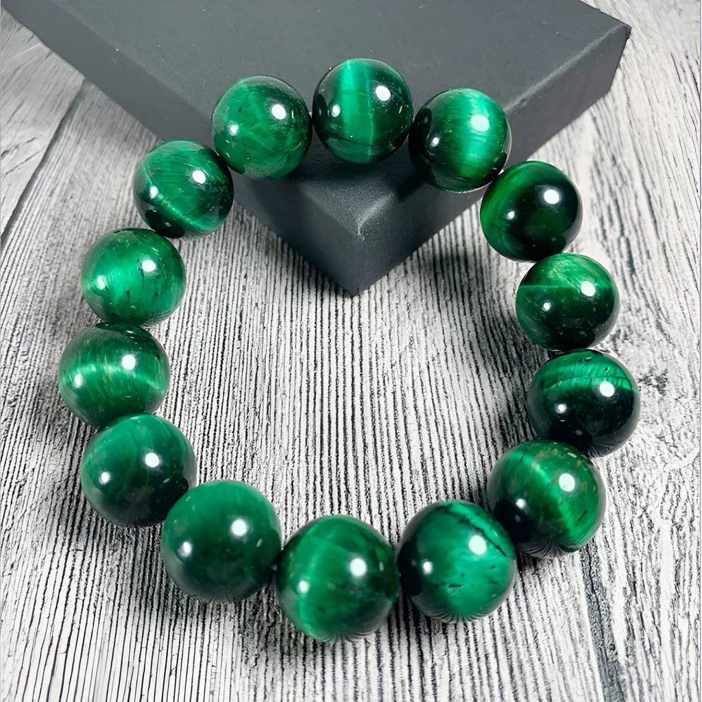 Green tiger eye gemstone bracelet with geometrically polished beads on a white background.